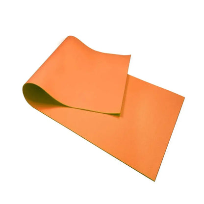 Colchoneta de yoga y pilates hecha de material EVA color naranja brillante para entrenamientos en casa y gimnasio.