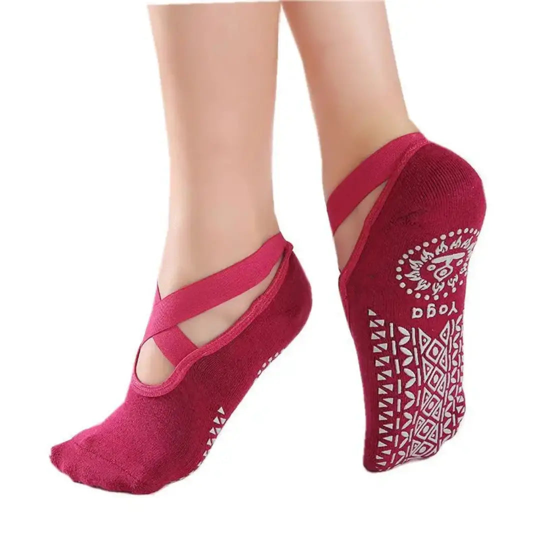 Modelo usando medias antideslizantes color conchevino guinda sobre mat de yoga, ideal para ensayos de marinera.