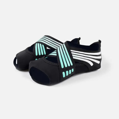Calzado deportivo elástico para pilates y danza en color negro con detalles de líneas verde turquesa.