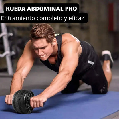 Hombre en el gimnasio realizando entrenamiento de core y estabilidad usando un rodillo para abdominales sobre un mat.